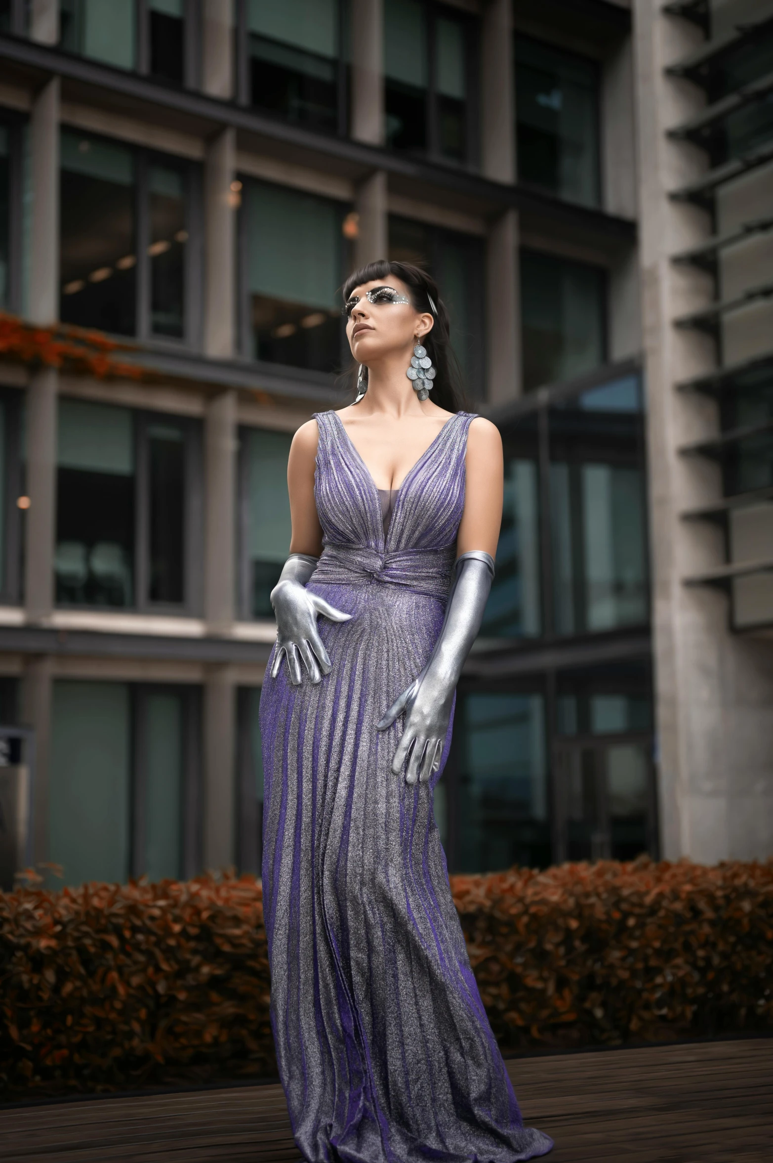 a woman dressed in purple poses with a skyscr in the background