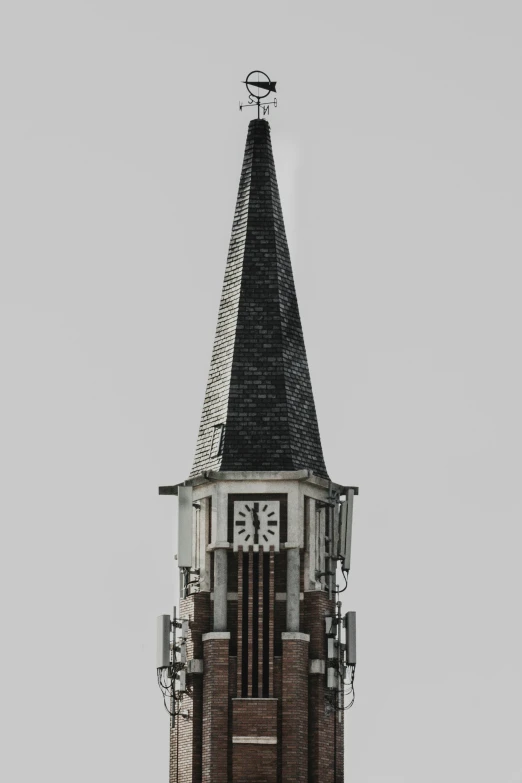 a tall brick clock tower with a weather vein and a weather vane