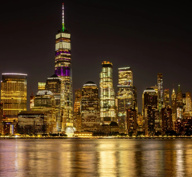 the skyline is illuminated brightly at night from across the bay