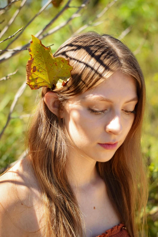 a girl in a dress is looking at a leaf