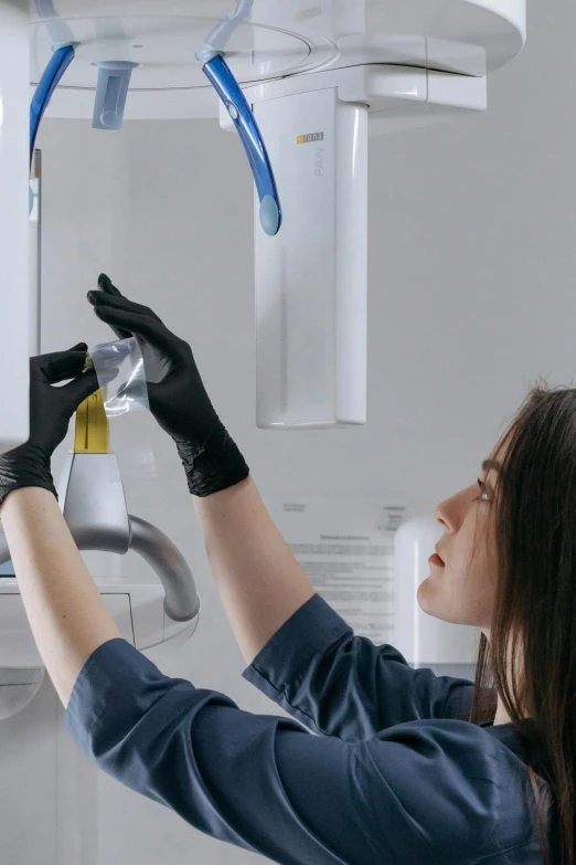 the woman in gloves is adjusting the lights on the ceiling