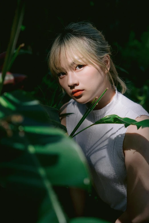 a girl standing in a forest near leaves