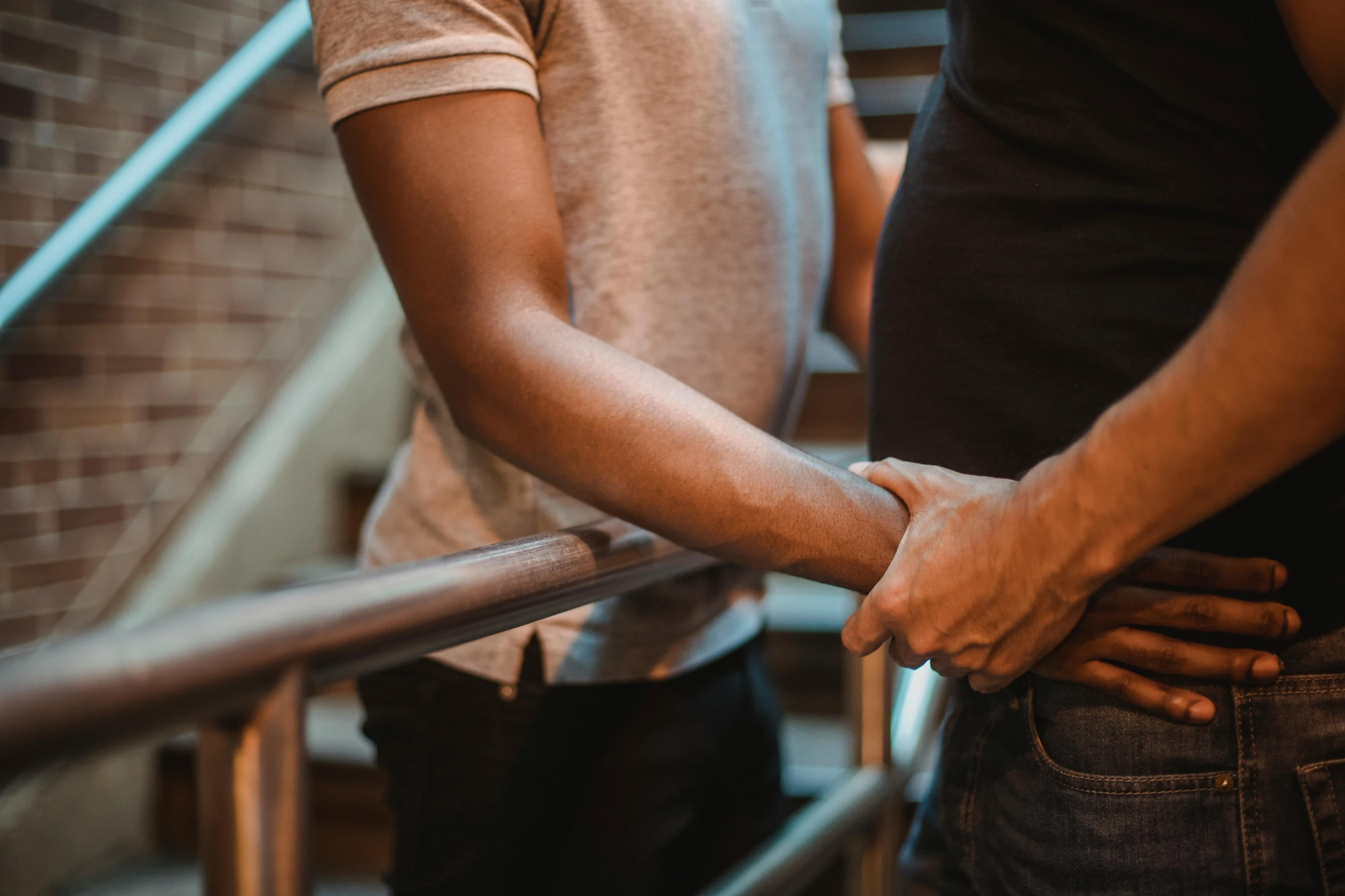 two people are pulling hands on a railing