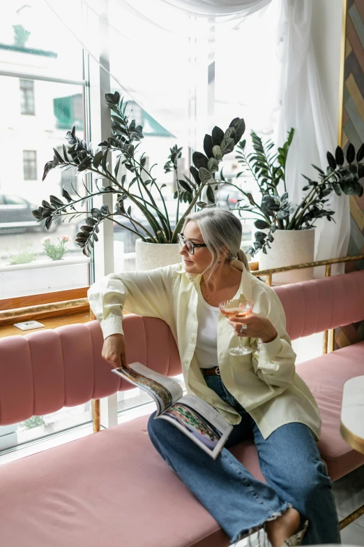 a woman sitting on a pink bench with a cup