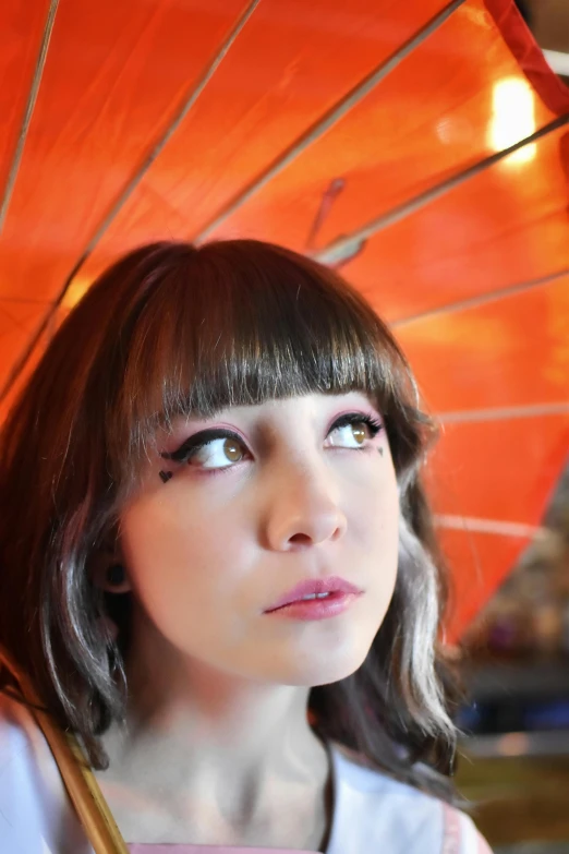 a close up of a person with an orange umbrella