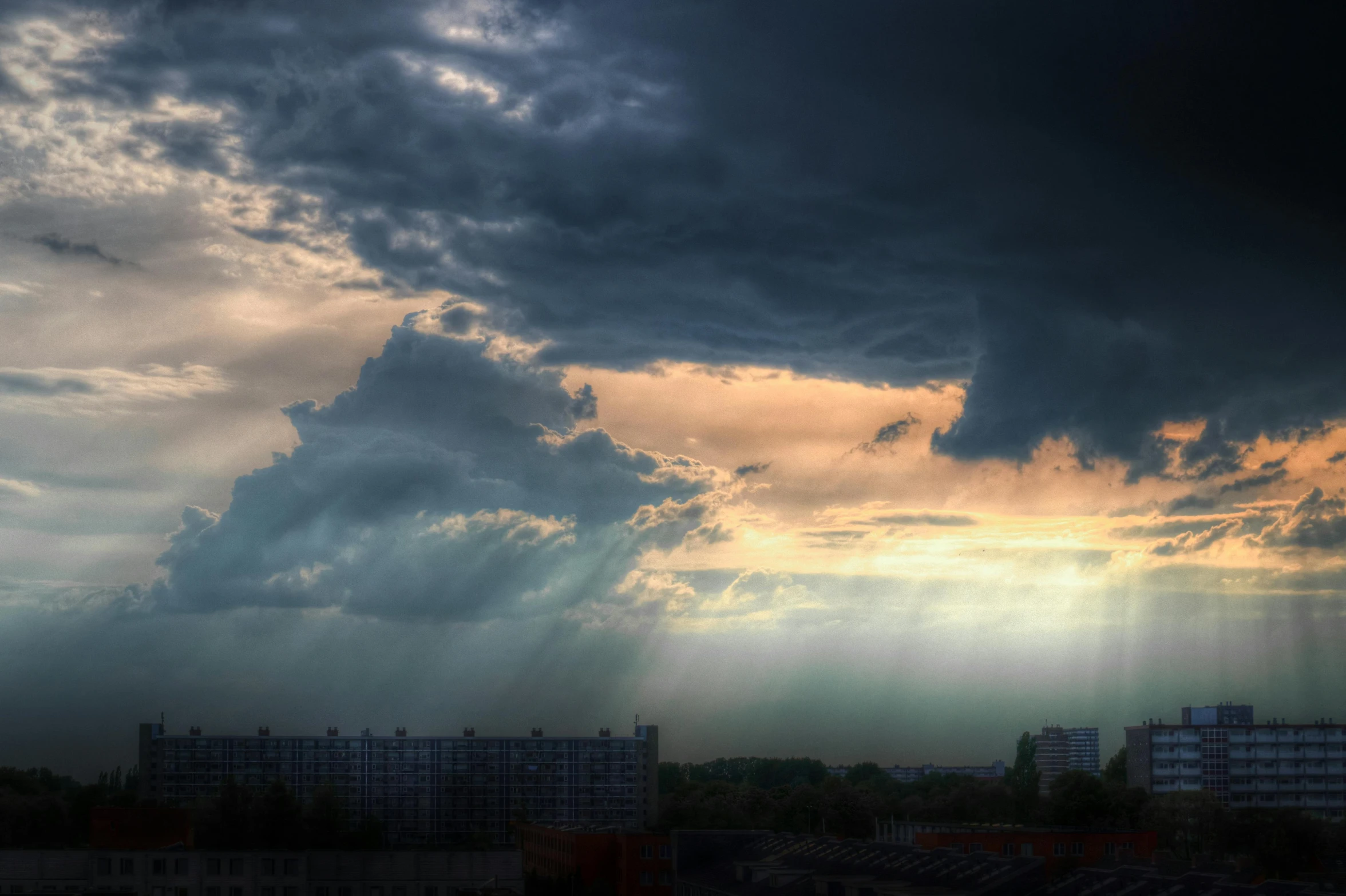 an airplane is sitting in the air while dark clouds hover over buildings