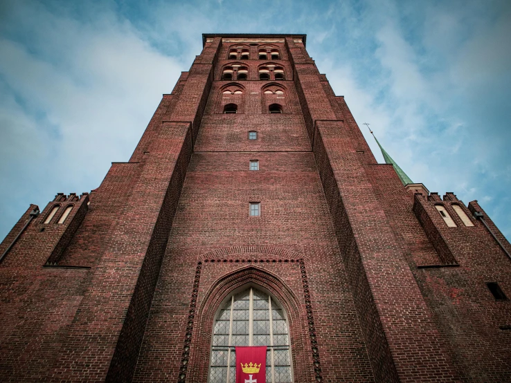 the tall brick tower has a red flag on it