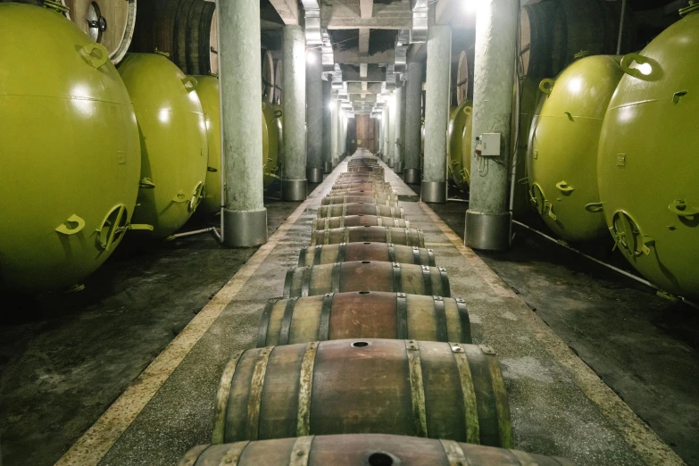 a row of wine barrels in a warehouse