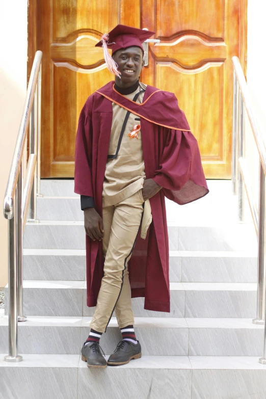 the black man is posing for a po in his graduation regall