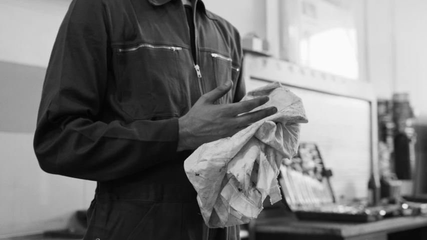 black and white po of man holding napkins in an office