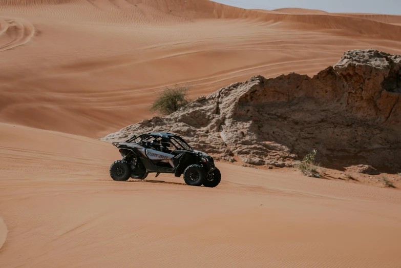 a four wheeler driving up a hill in the desert