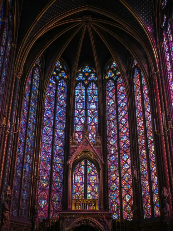 some stained glass windows and an altar with a cross