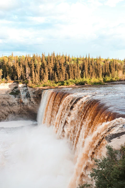 a very large waterfall with a treed area near the side