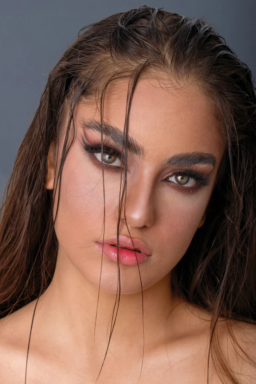 a woman with long brown hair is posing for the camera