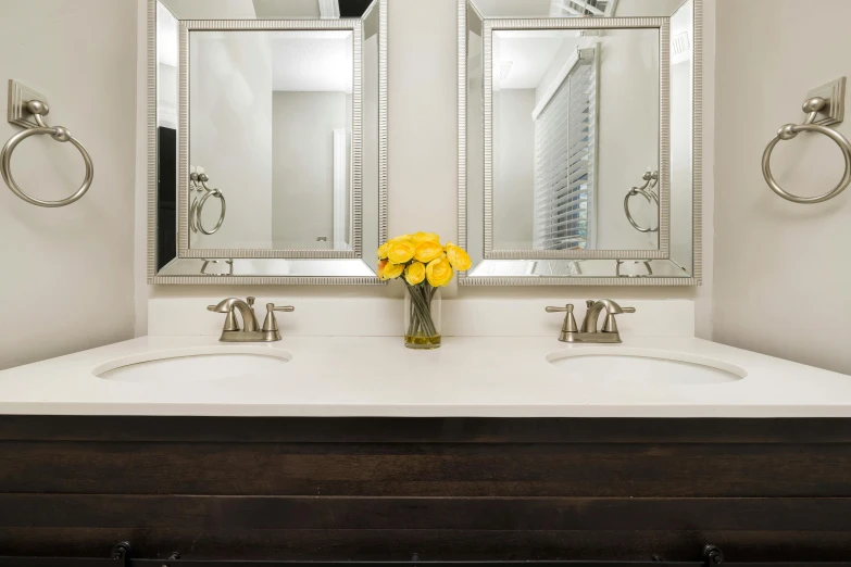 there is a bouquet of flowers in front of the double sinks