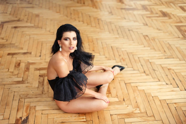 a woman with long hair sits on the floor