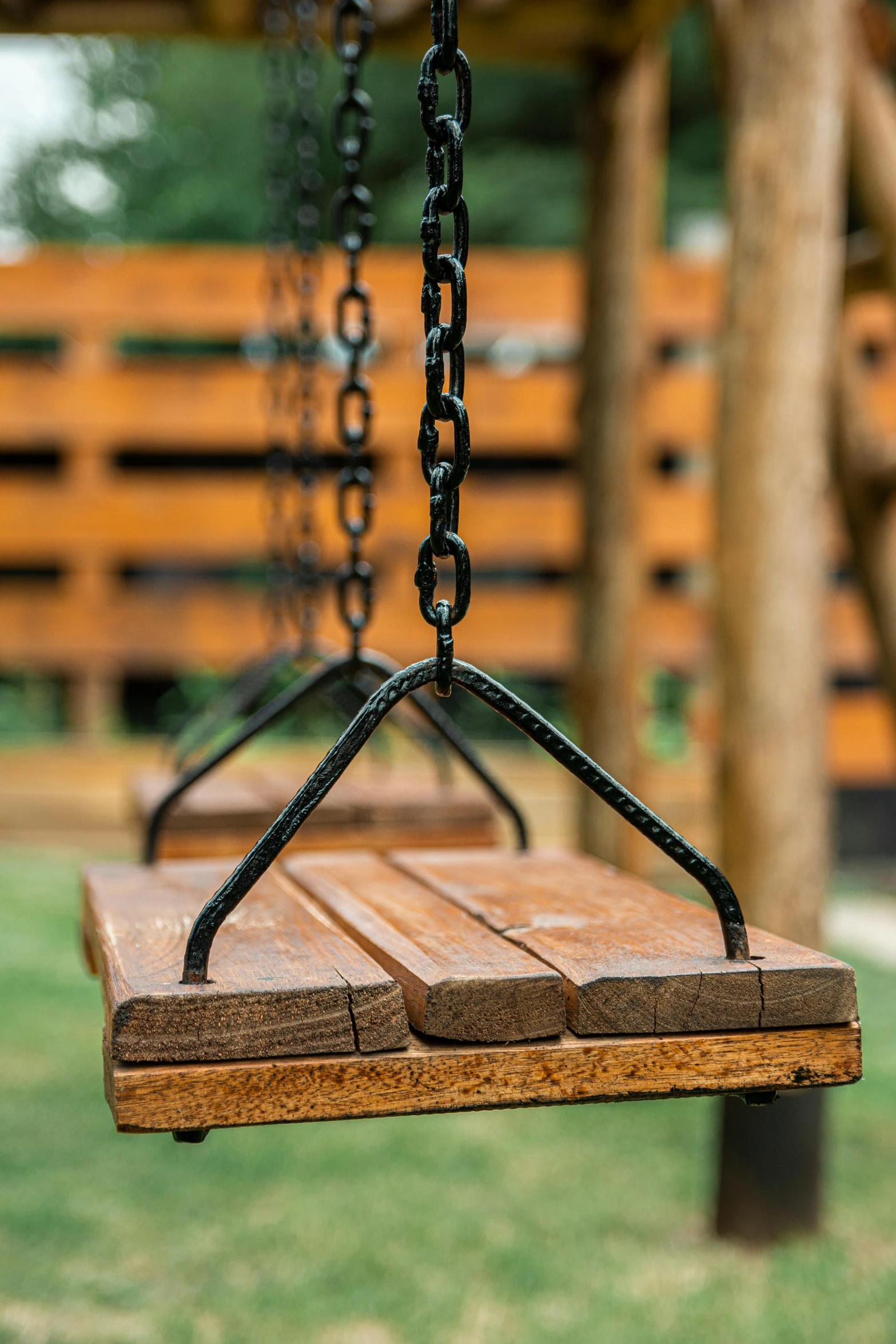 the large wooden swing is attached to a tree