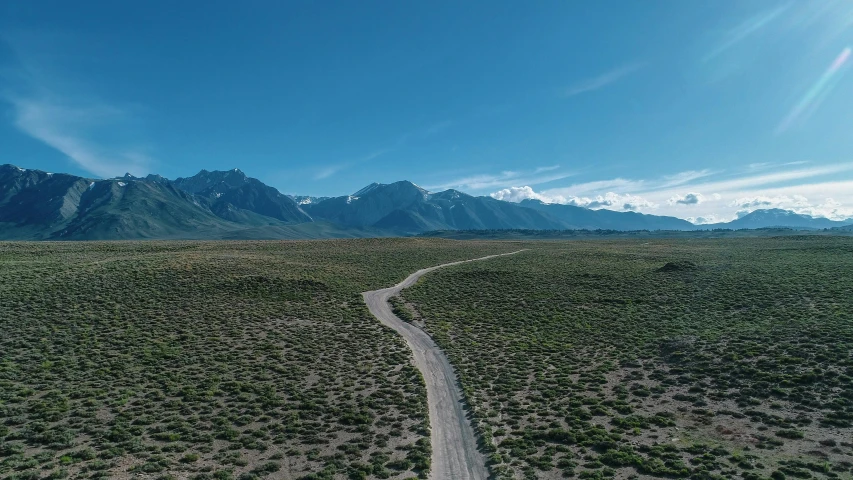 an aerial view of a desert with mountains and trees