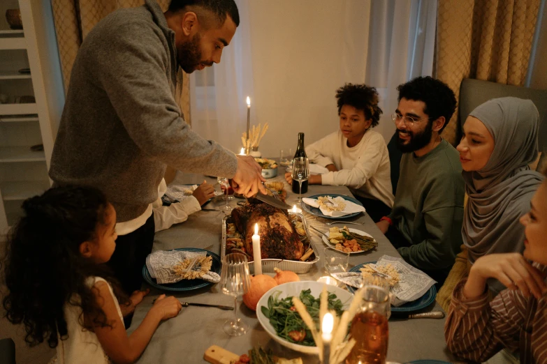 a group of people sitting around a table sharing a meal with someone