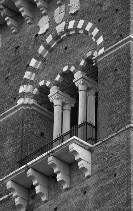 black and white pograph of balcony railing on brick building