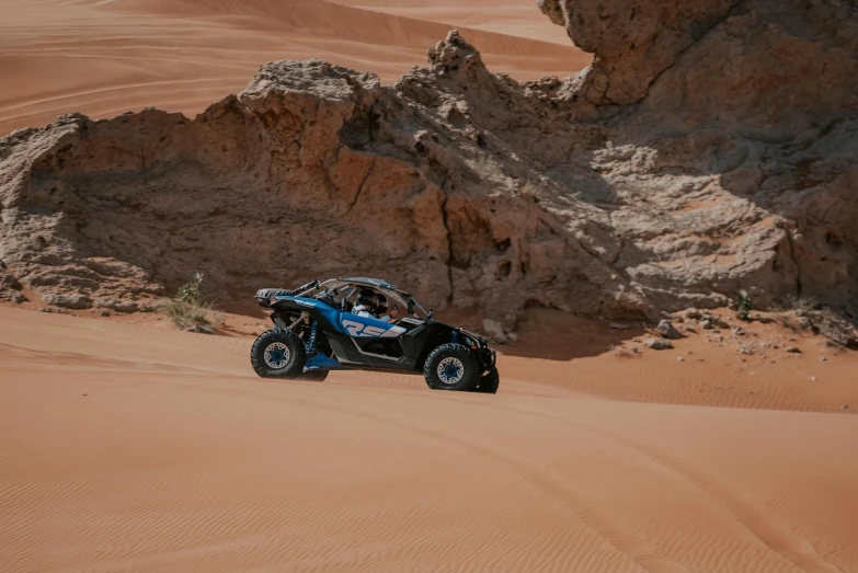 a car driving in the desert with sand