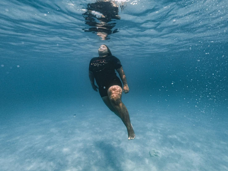 a man is diving in the water under the blue water