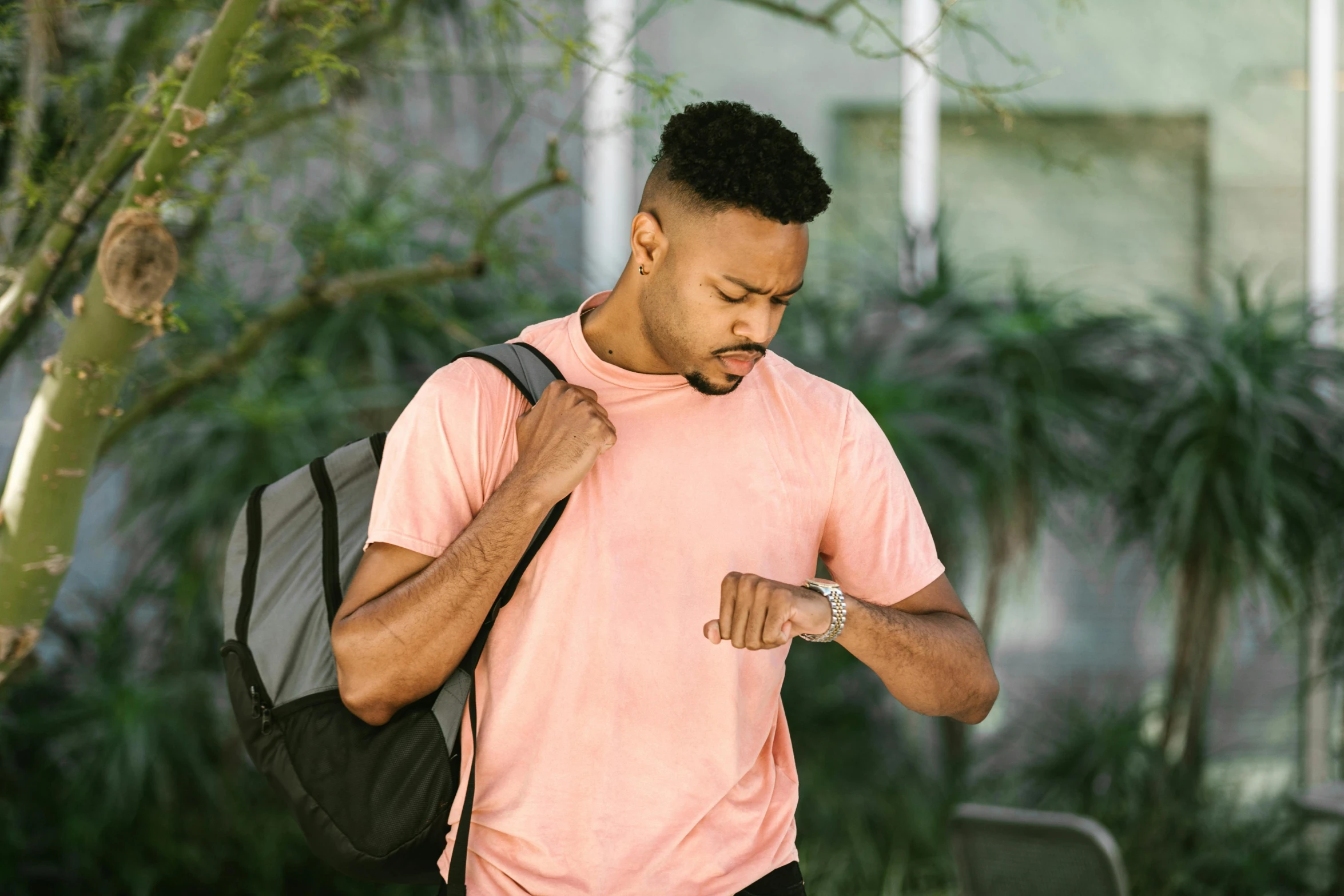 a man holding a backpack while walking through a forest