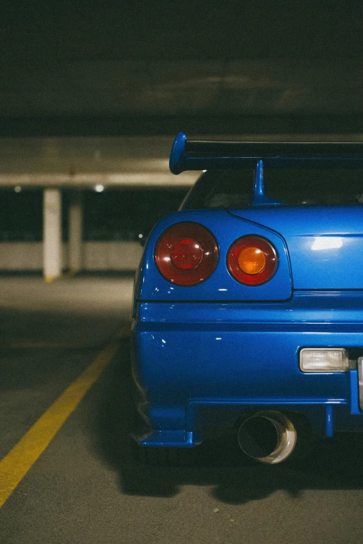 blue car with hood up is parked in a parking garage