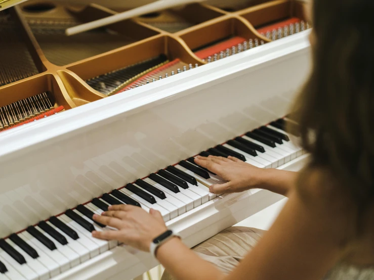 a person is sitting at the piano playing the keys