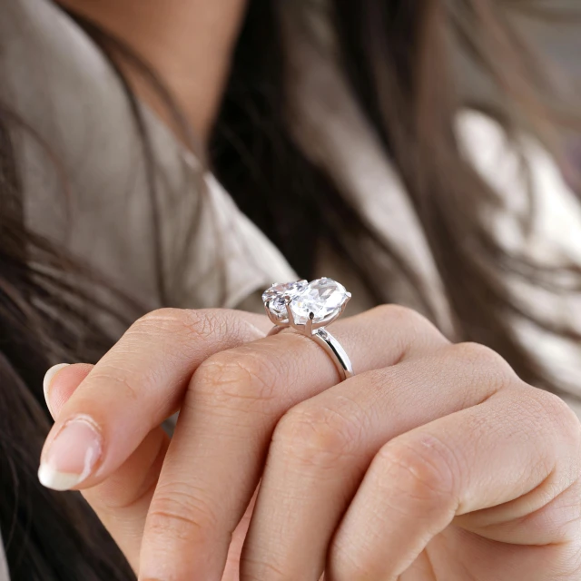 a woman holding her engagement ring in her hand