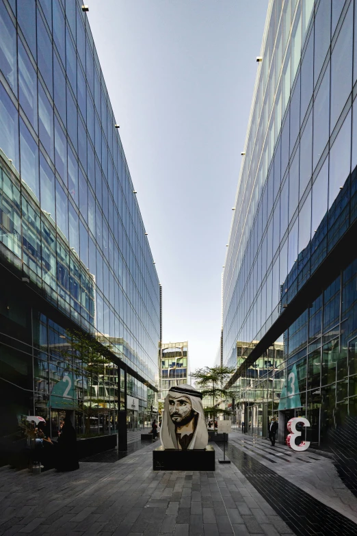 two tall glass buildings with a small statue in the center