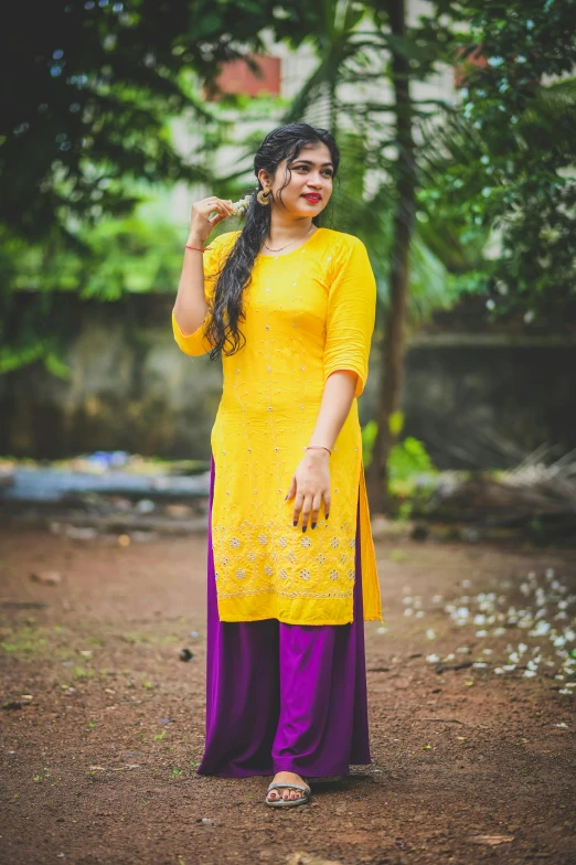 woman dressed in yellow and purple clothing posing