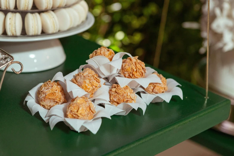 a green table topped with desserts on top of a green counter