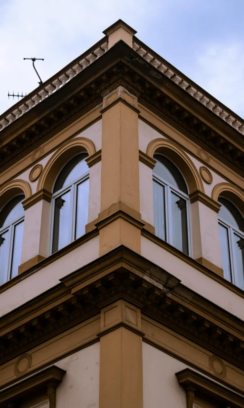 a very tall tan building with multiple windows