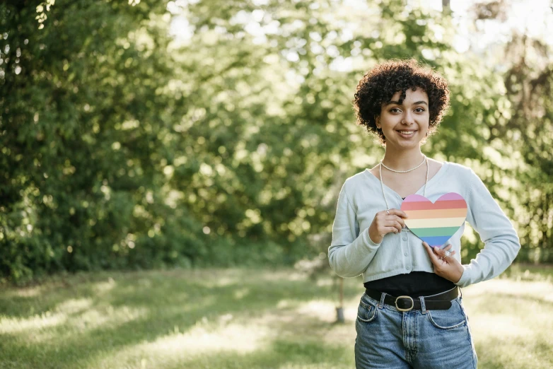 a woman standing outside and holding a heart shaped box