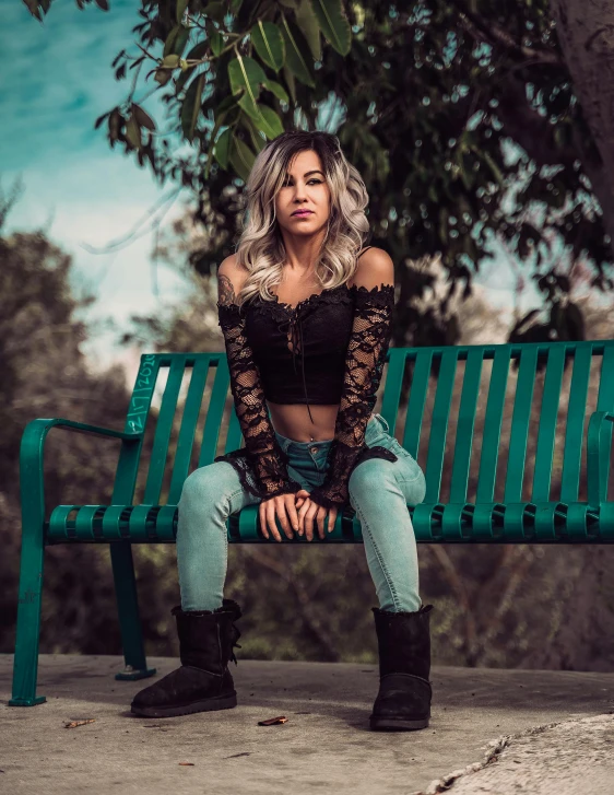 a woman sitting on top of a green bench