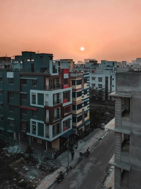 buildings are standing in an urban area against a bright pink sky