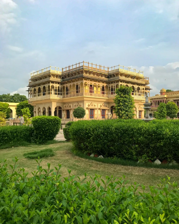 an old style house is under construction and has many bushes