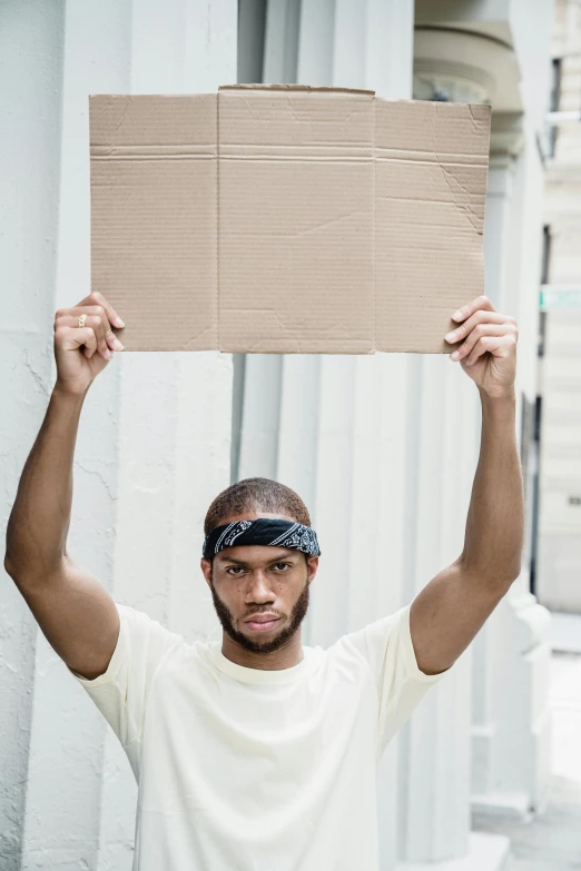 a young man holds up a cardboard box