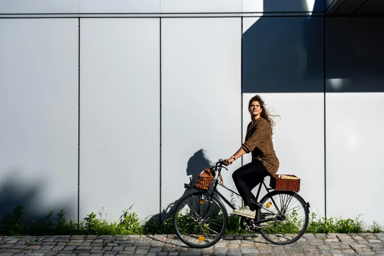 a woman riding a bicycle down a sidewalk