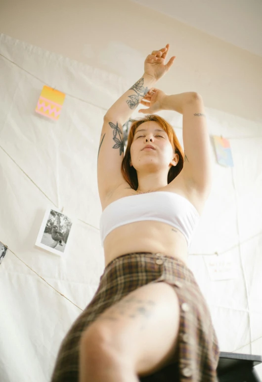 a woman in shorts and cropped top tossing her arms up