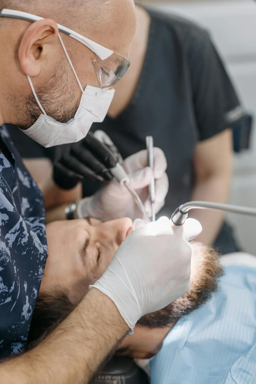 dentist demonstrating procedure on young male patient in operating room