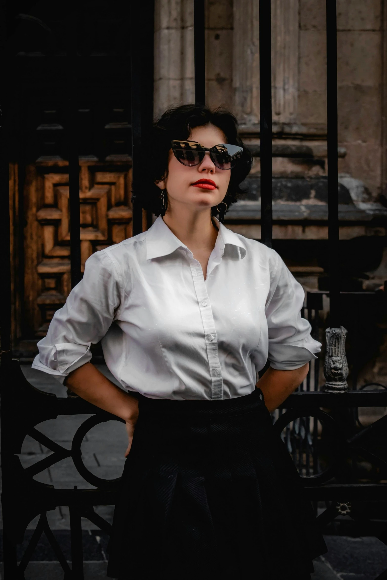 a woman in white shirt and black skirt with sunglasses