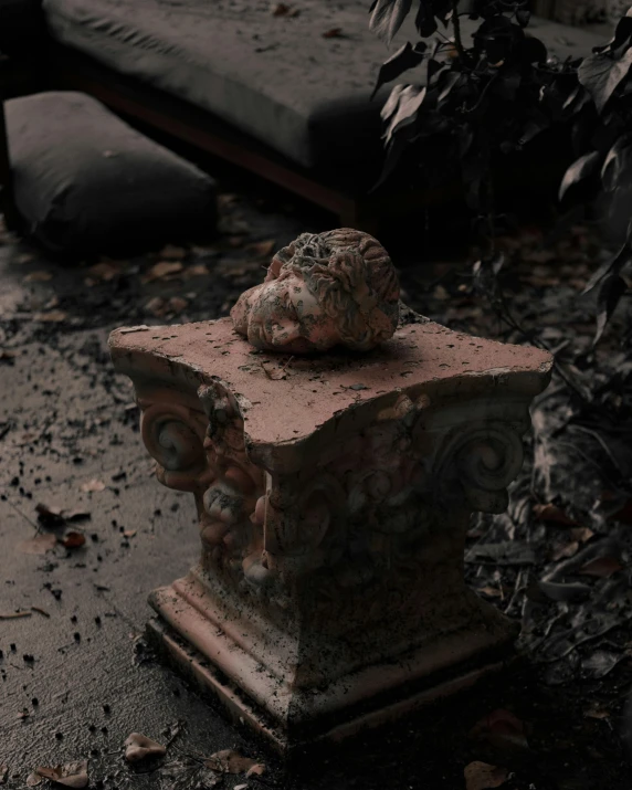 a cement bench with two faces, in the center of some weeds