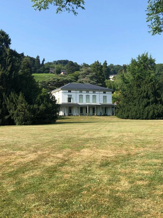 a big house with some trees in front