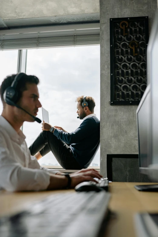 two men sitting in front of a computer