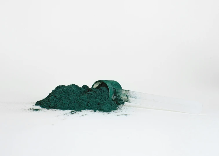 a pile of green powder next to the snow