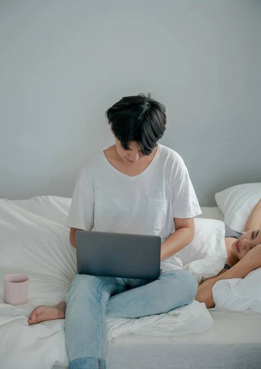 two people laying down while looking at a laptop