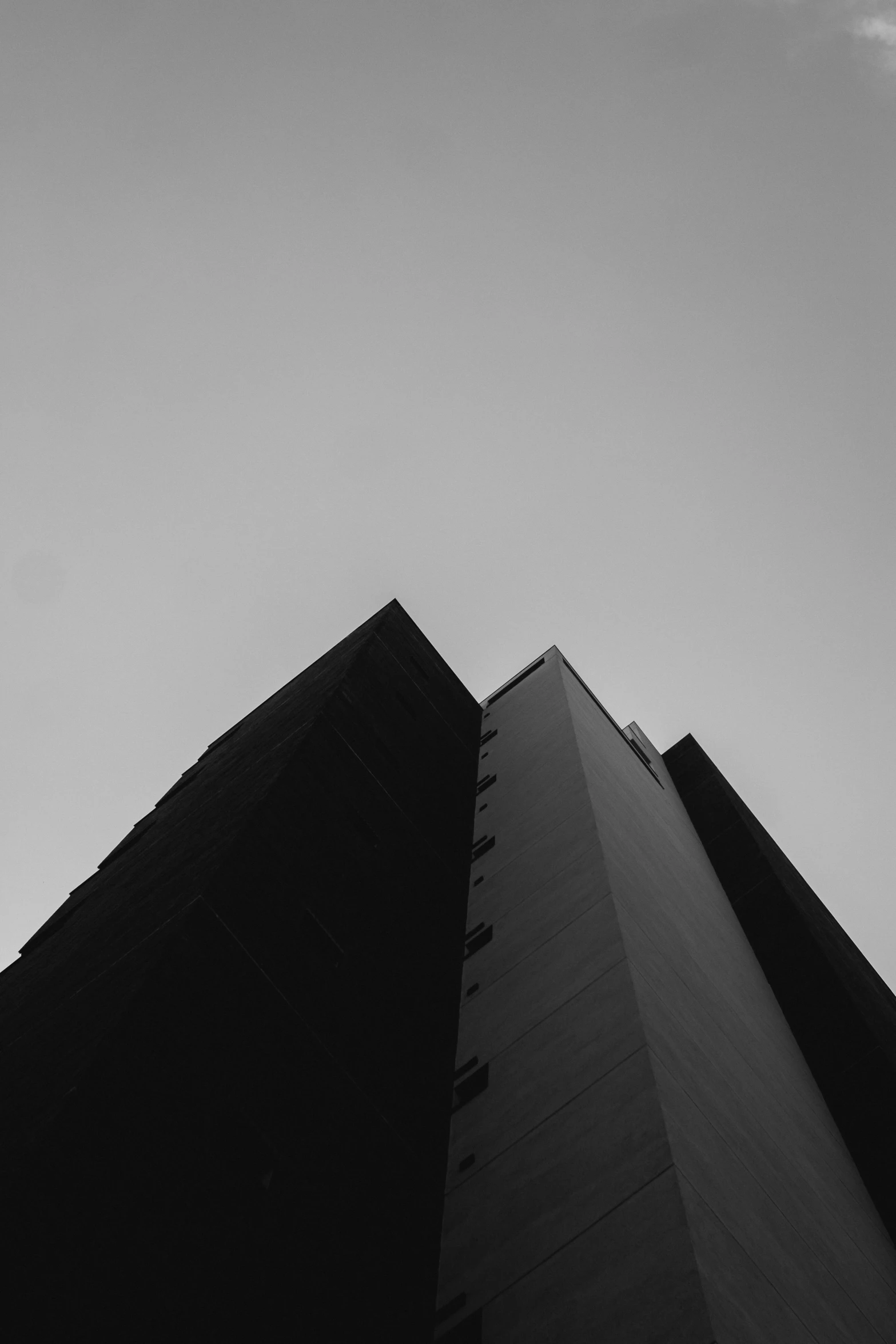 a tall black building stands near another large building