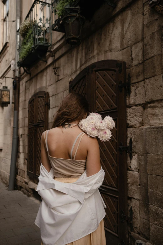 woman walking down the street wearing a dress and a flower pinned on her hair